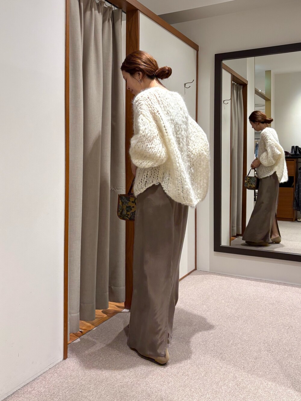 ホワイト系のニット/セーター、ブラック系のローファー、グリーン系のスカートを着用したレディースの秋コーディネートの4枚目の写真