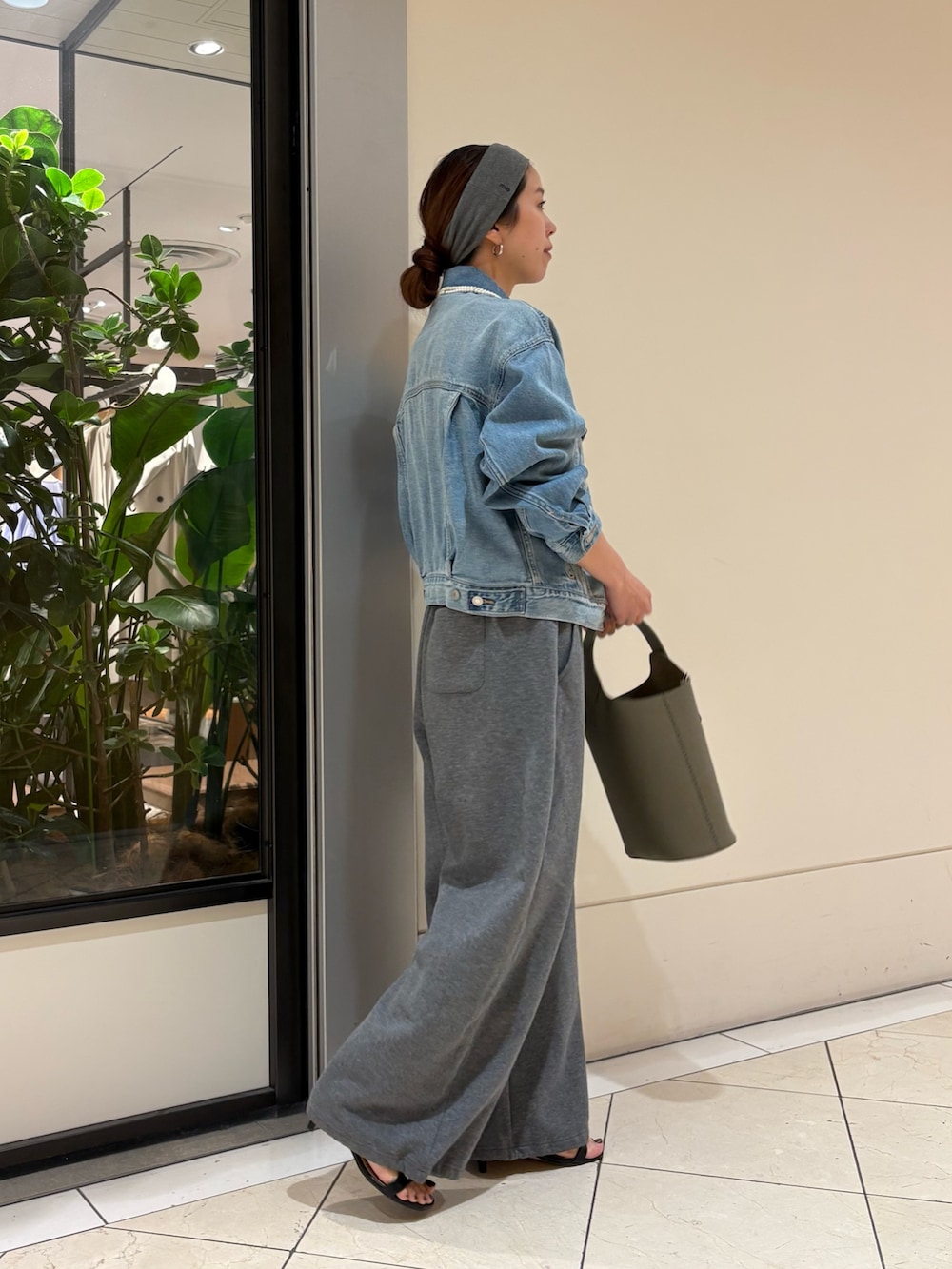 ブルー系のデニムジャケット、グリーン系のハンドバッグ、グレー系のヘアバンドを着用したレディースの春コーディネートの3枚目の写真