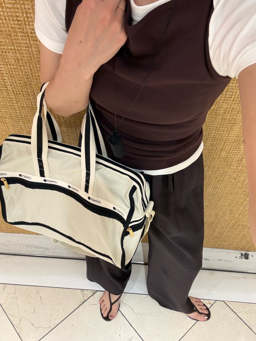 グレー系のその他パンツ、ブラウン系のタンクトップ、ベージュ系のショルダーバッグを着用したレディースの夏コーディネートの7枚目の写真