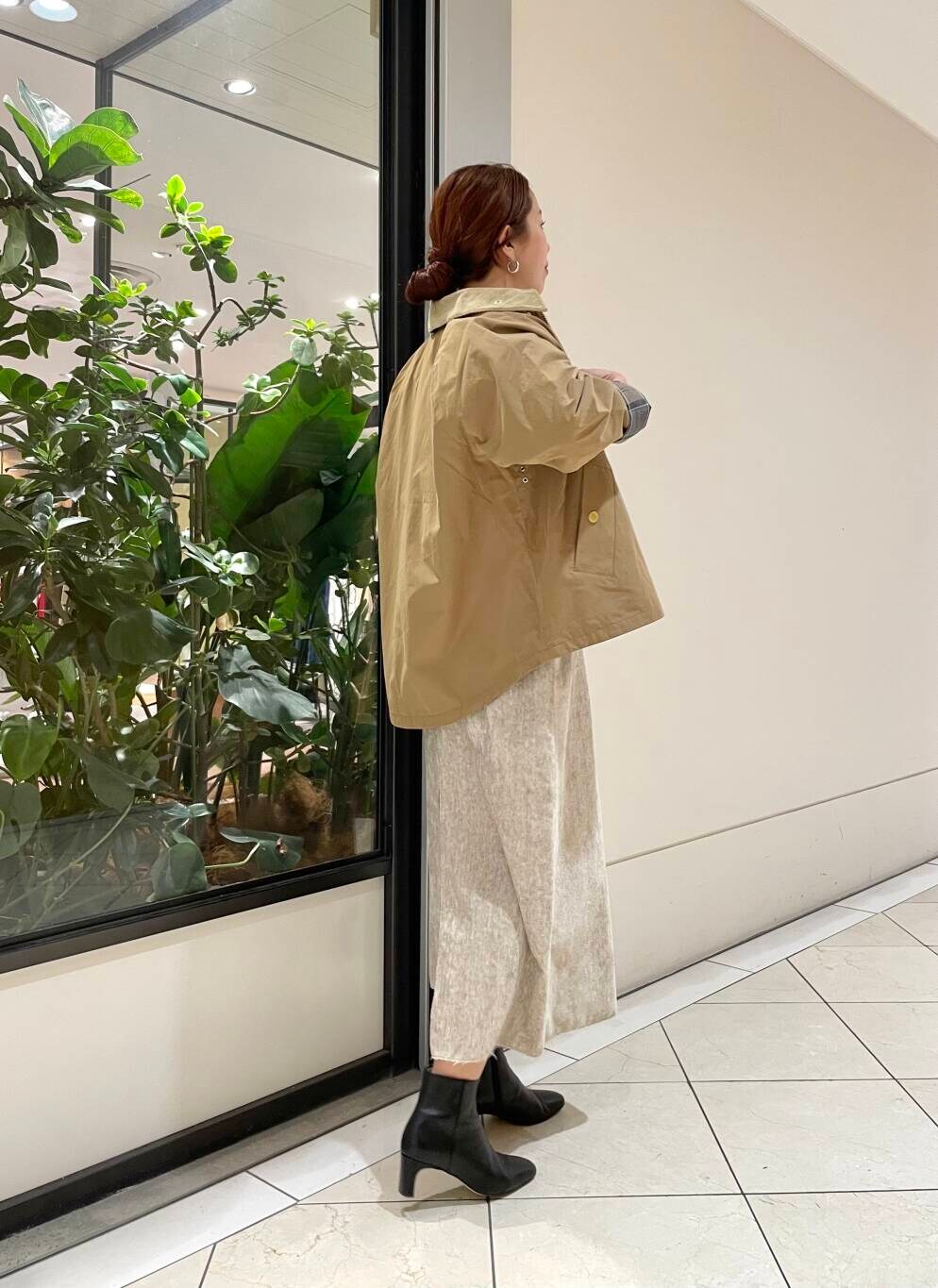 イエロー系のTシャツ/カットソー、ベージュ系のワンピース、ホワイト系のニット/セーターを着用したレディースの冬コーディネートの3枚目の写真