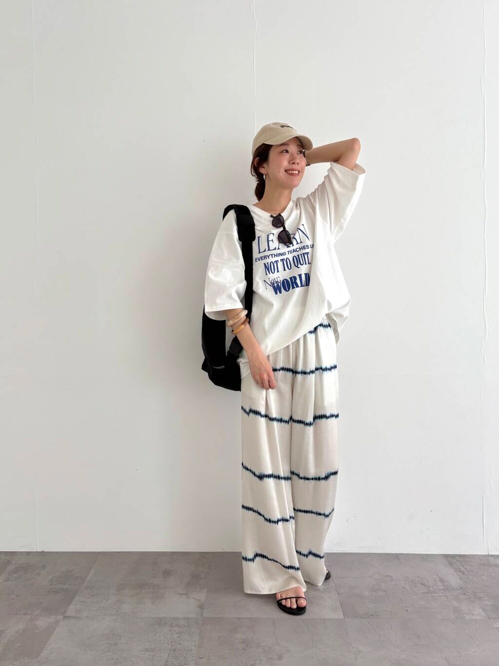 ブラック系のバックパック/リュック、その他のTシャツ/カットソー、ブラック系のサンダルを着用したレディースの春コーディネートの7枚目の写真