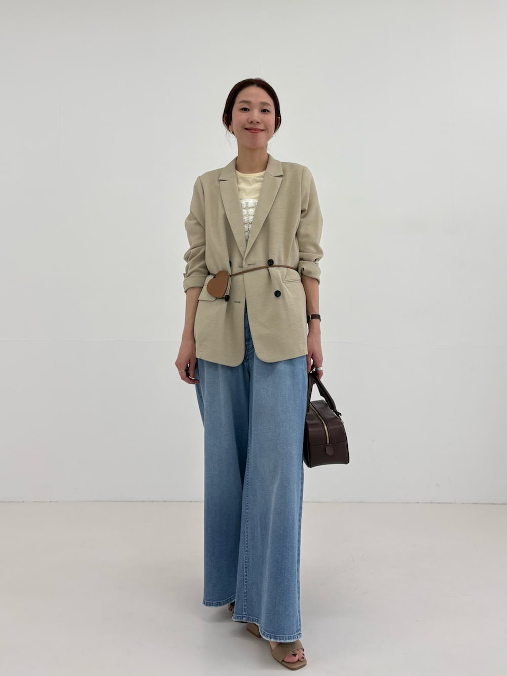 ベージュ系のその他アウター、イエロー系のTシャツ/カットソー、ブルー系のデニムパンツを着用したレディースの春コーディネートの6枚目の写真