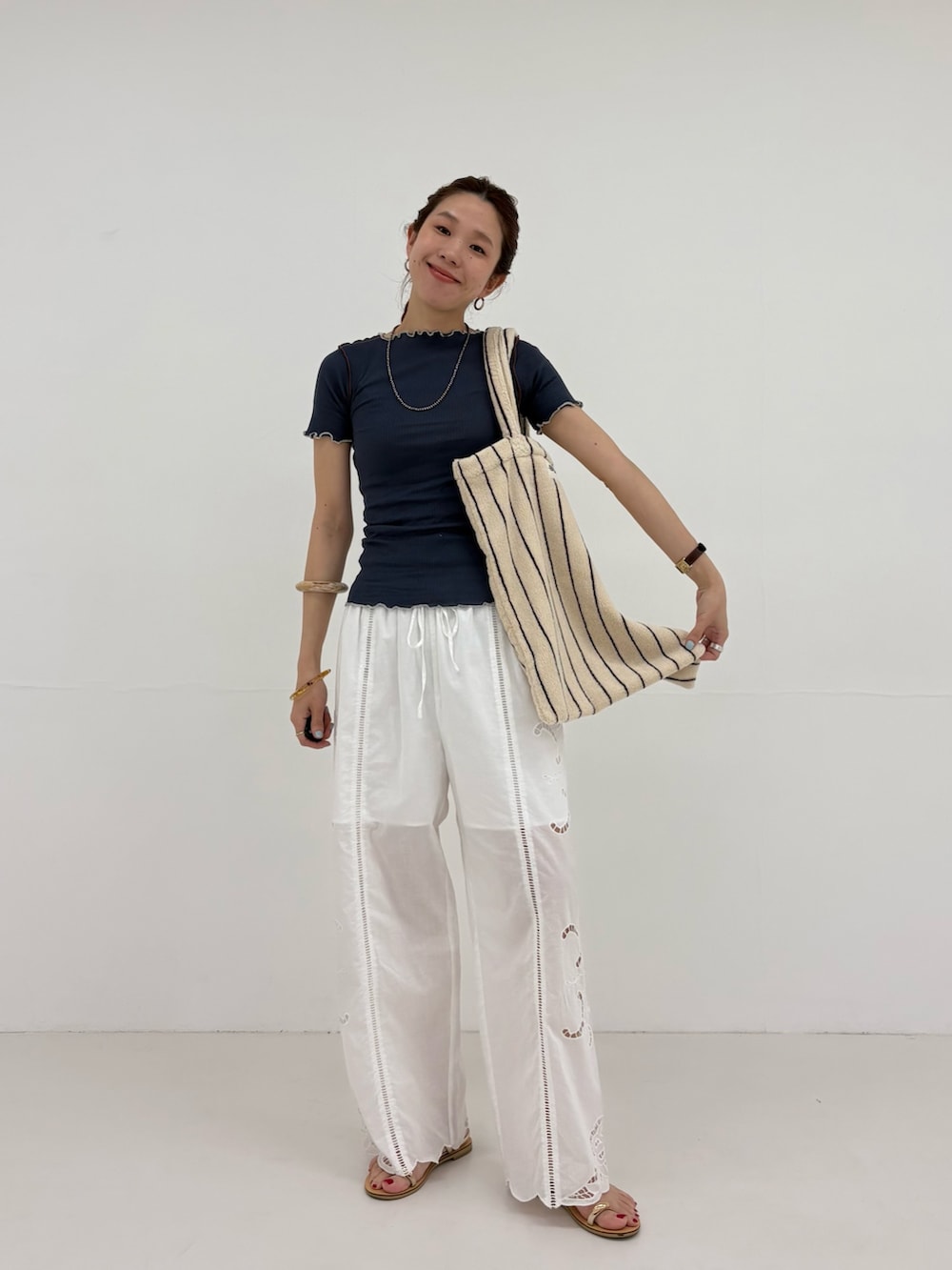 ブルー系のTシャツ/カットソー、ホワイト系のその他パンツ、ホワイト系のトートバッグを着用したレディースの春コーディネートの5枚目の写真