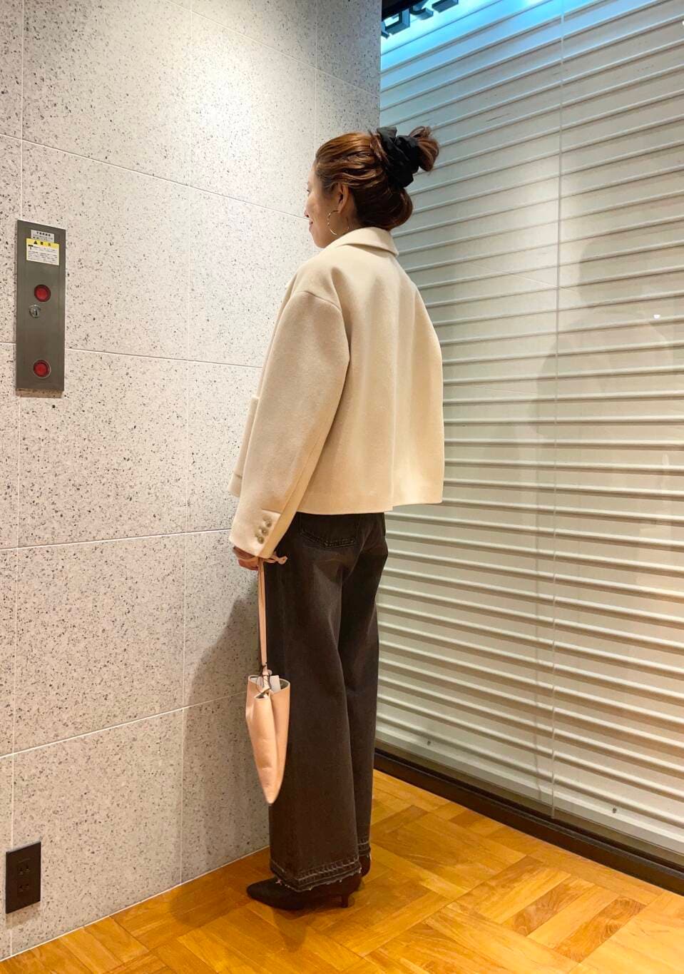 ブラック系のデニムパンツ、ブラウン系のニット/セーター、ブラック系のブーツを着用したレディースの冬コーディネートの4枚目の写真