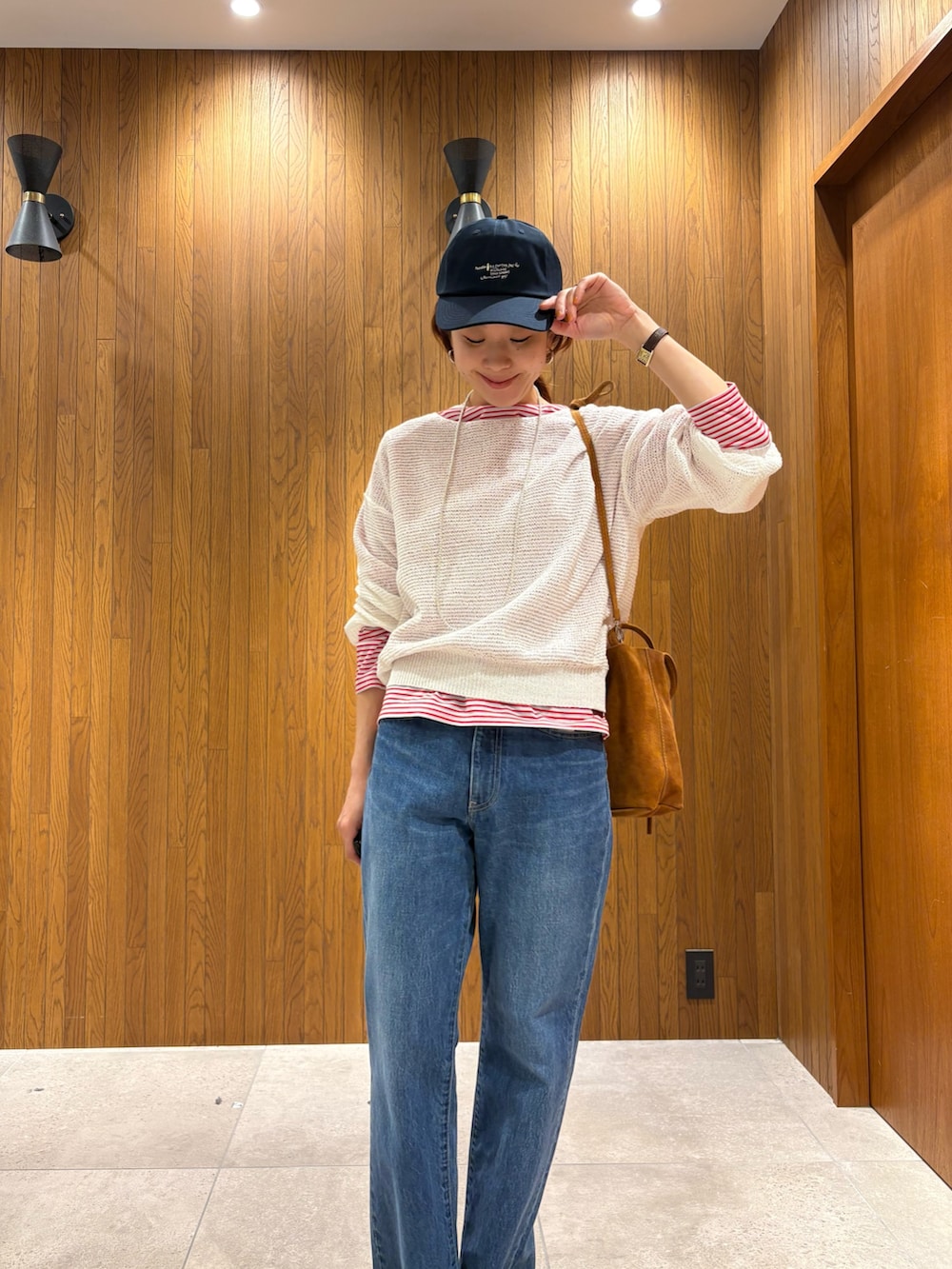 ベージュ系のトレンチコート、レッド系のTシャツ/カットソー、ホワイト系のニット/セーターを着用したレディースの春コーディネートの7枚目の写真