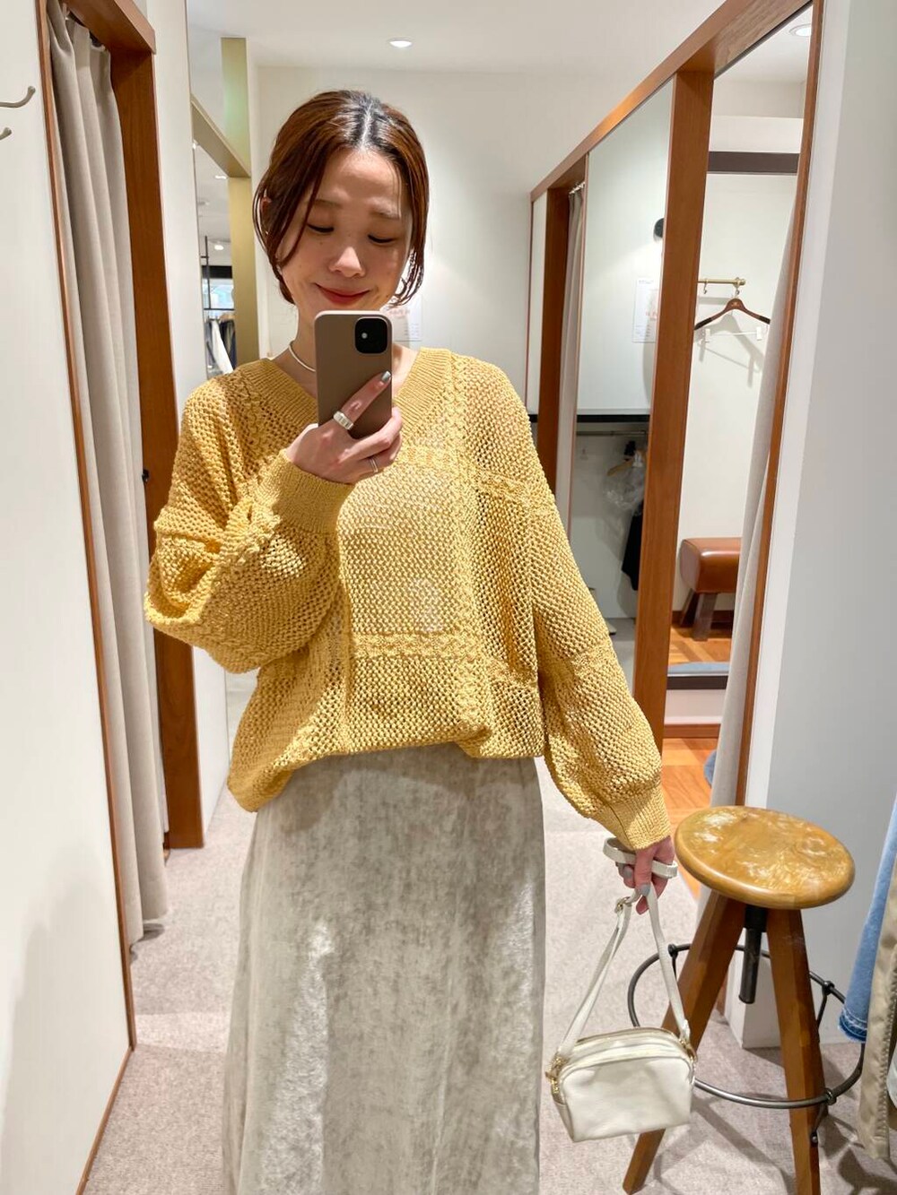 ホワイト系のショルダーバッグ、ベージュ系のスカート、イエロー系のニット/セーターを着用したレディースの冬コーディネートの7枚目の写真