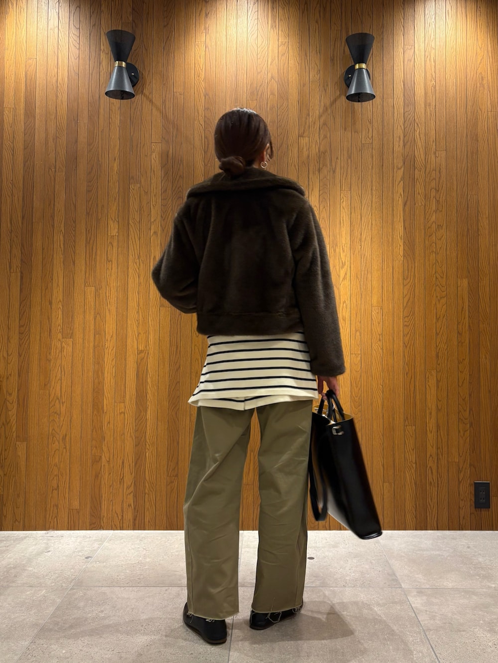 イエロー系のニット/セーター、ベージュ系のその他パンツ、ブラック系のハンドバッグを着用したレディースの冬コーディネートの8枚目の写真