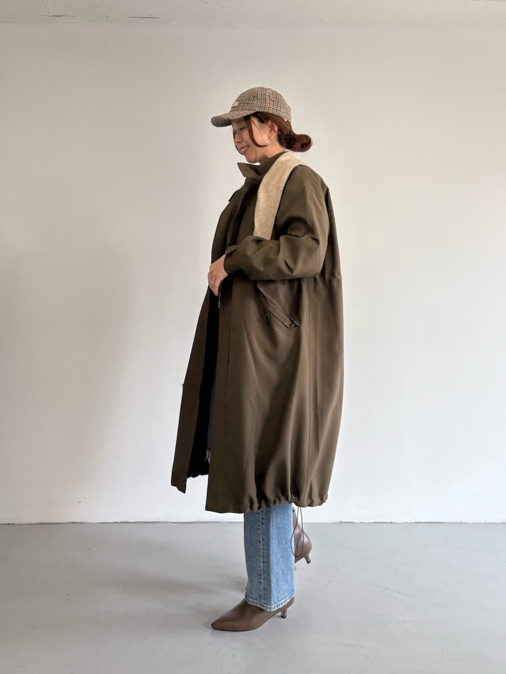 ブルー系のデニムパンツ、ベージュ系のトートバッグ、ホワイト系のTシャツ/カットソーを着用したレディースの冬コーディネートの5枚目の写真