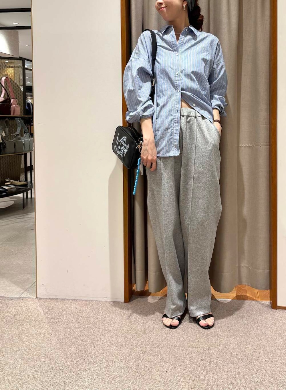 ブルー系のシャツ/ブラウス、ブラック系のショルダーバッグ、グレー系のその他パンツを着用したレディースの春コーディネートの2枚目の写真