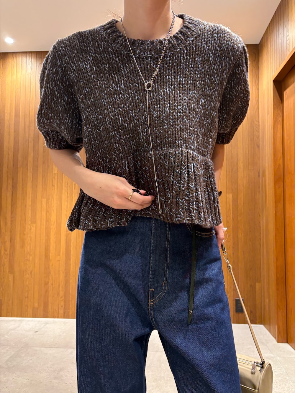 ブルー系のデニムパンツ、ブラウン系のニット/セーター、ベージュ系のハンドバッグを着用したレディースの秋コーディネートの8枚目の写真