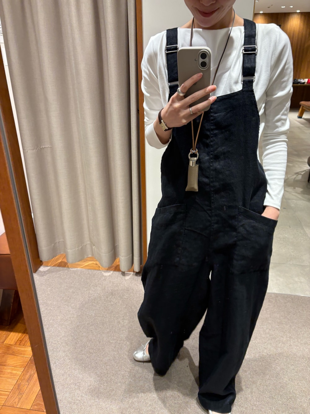 ブラック系のサロペット/オーバーオール、ホワイト系のTシャツ/カットソー、パープル系のハンドバッグを着用したレディースの春コーディネートの6枚目の写真