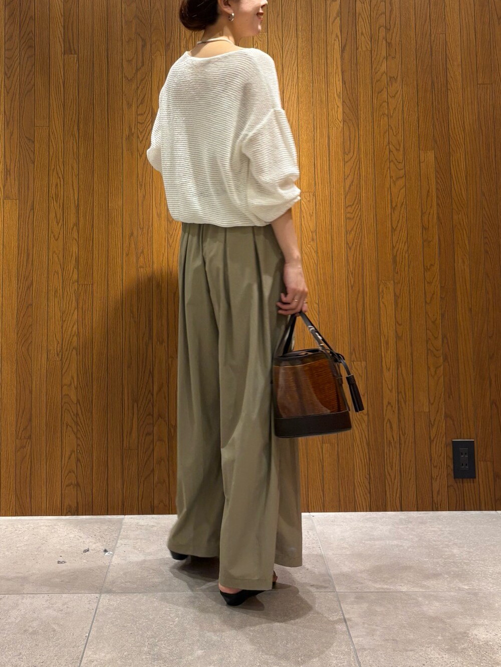 ホワイト系のニット/セーター、ベージュ系のその他パンツ、ブラウン系のかごバッグを着用したレディースの春コーディネートの4枚目の写真