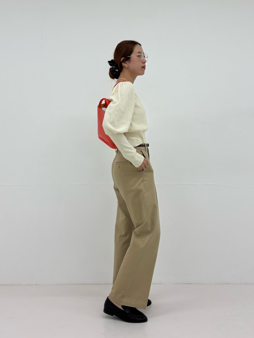 ホワイト系のニット/セーター、ベージュ系のその他パンツ、ブラック系のローファーを着用したレディースの夏コーディネートの5枚目の写真