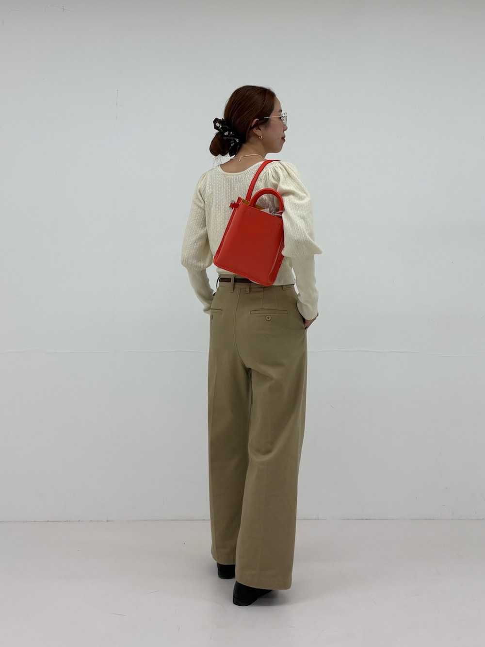 ホワイト系のニット/セーター、ベージュ系のその他パンツ、ブラック系のローファーを着用したレディースの夏コーディネートの4枚目の写真