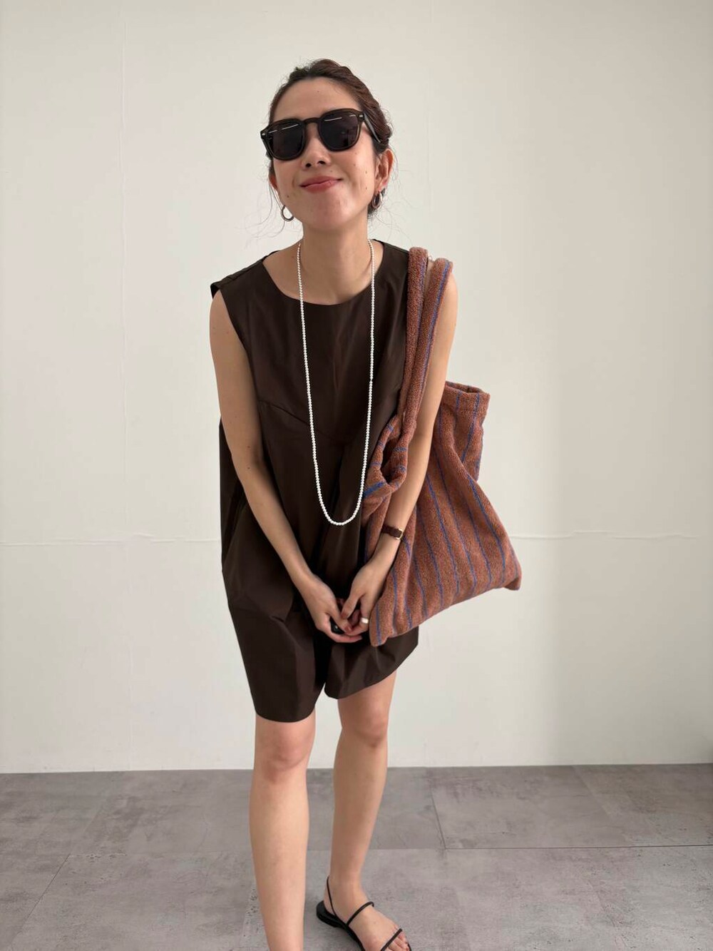 ブラック系のサンダル、その他のメガネ、ブラウン系の水着を着用したレディースの夏コーディネートの6枚目の写真