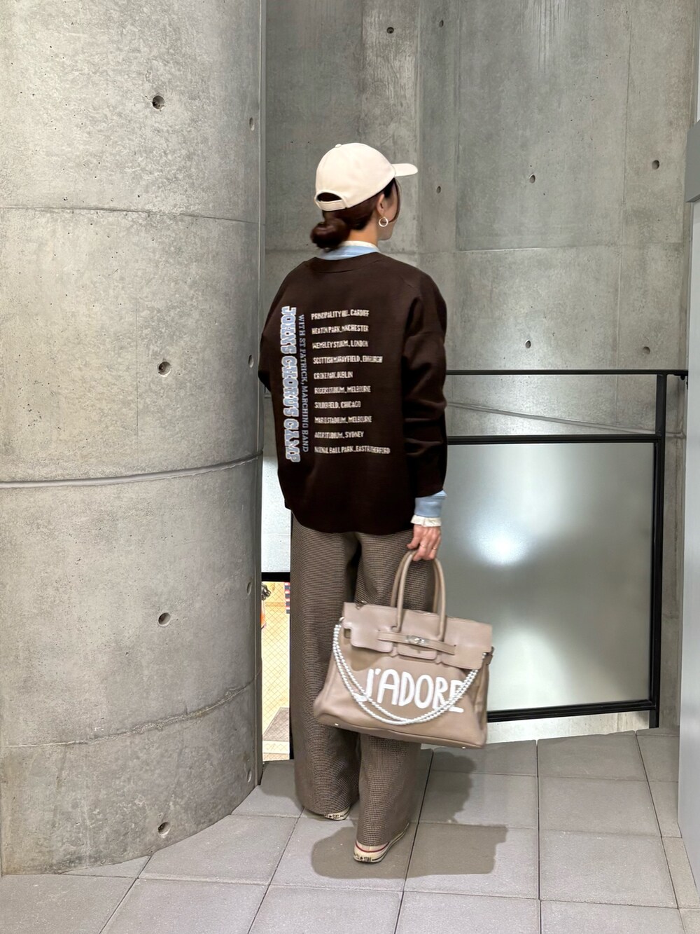 イエロー系のその他パンツ、ブルー系のTシャツ/カットソー、ベージュ系のハンドバッグを着用したレディースの秋コーディネートの3枚目の写真