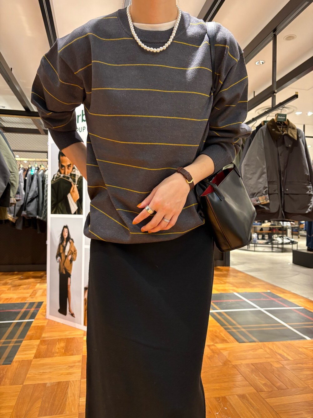 ブラック系のブーツ、ブラック系のショルダーバッグ、ブラック系のスカートを着用したレディースの秋コーディネートの6枚目の写真