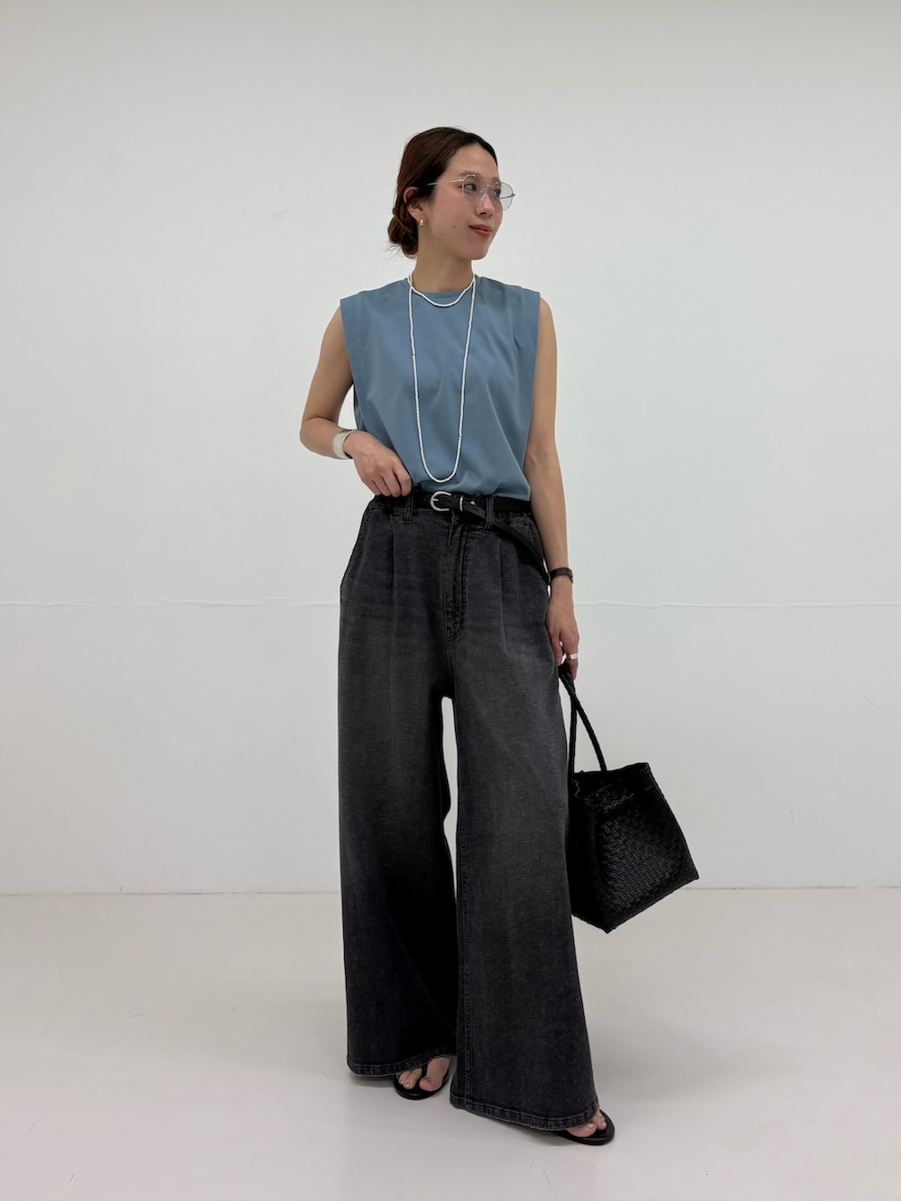 ブルー系のTシャツ/カットソー、ブラック系のトートバッグ、ブラック系のサンダルを着用したレディースの夏コーディネートの5枚目の写真
