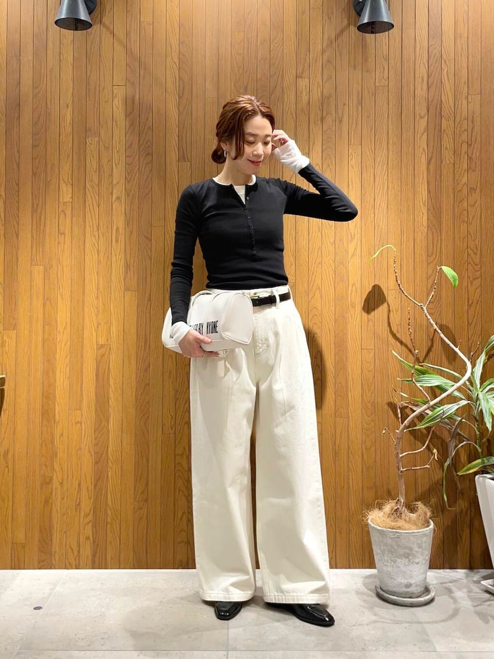 ブラック系のローファー、ホワイト系のボストンバッグ、ホワイト系のデニムパンツを着用したレディースの冬コーディネートの2枚目の写真