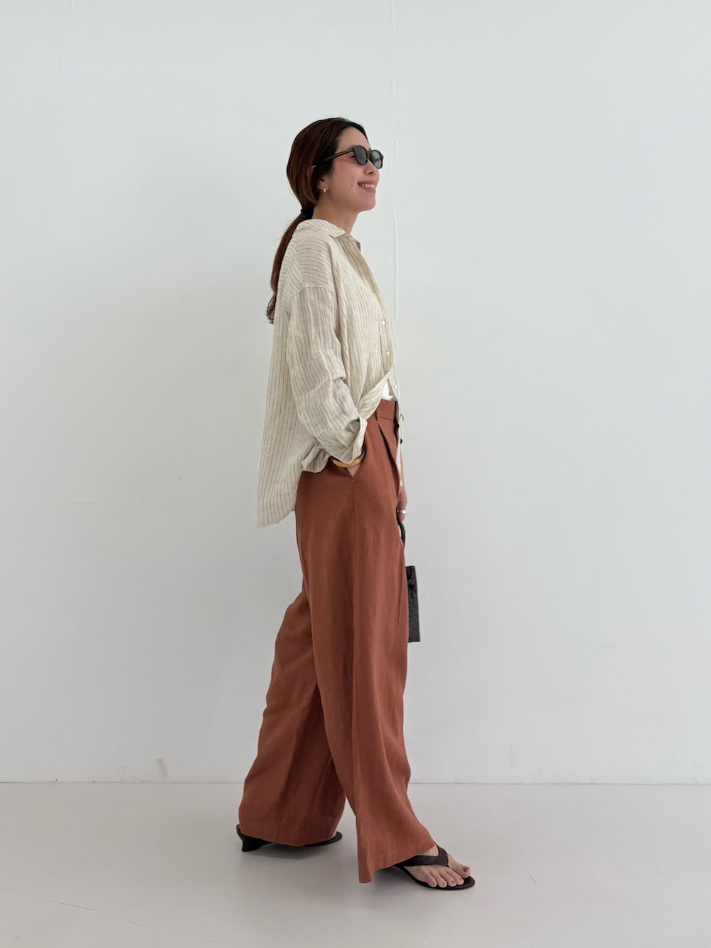 ベージュ系のシャツ/ブラウス、ブラウン系のその他パンツ、ブラウン系のトートバッグを着用したレディースの夏コーディネートの5枚目の写真