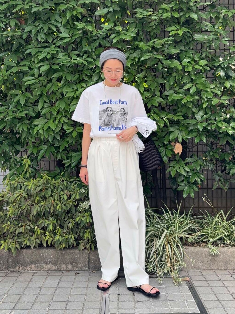 ブラック系のかごバッグ、ホワイト系のその他パンツ、ブラック系のサンダルを着用したレディースの夏コーディネートの5枚目の写真