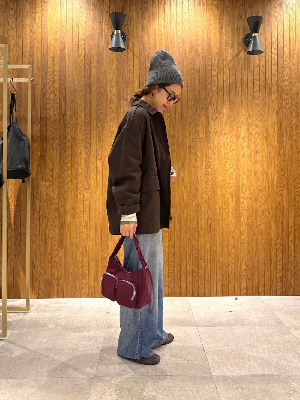 ホワイト系のニット/セーター、グリーン系のTシャツ/カットソー、ブラウン系のカバーオールを着用したレディースの秋コーディネートの2枚目の写真