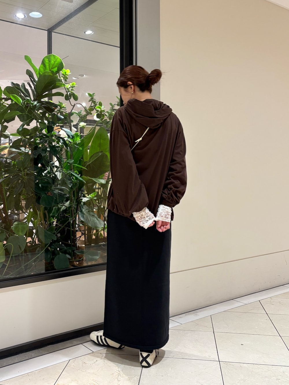 ブラウン系のパーカー、ホワイト系のスニーカー、ブラック系のスカートを着用したレディースの秋コーディネートの3枚目の写真