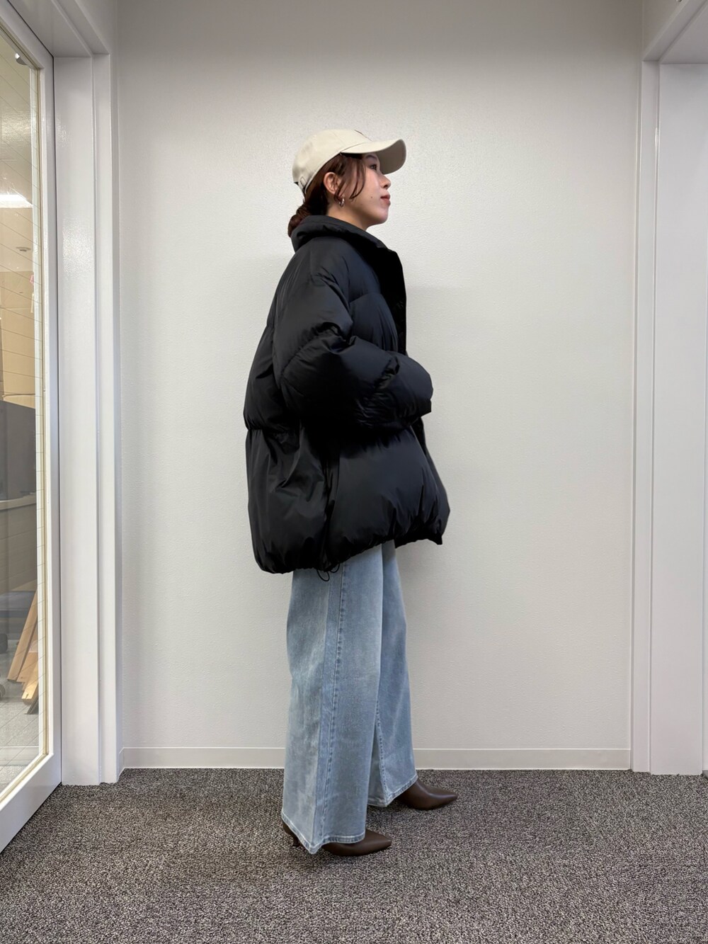 ブラック系のダウンジャケット/コート、ブルー系のデニムパンツ、ブラック系のダウンジャケット/コートを着用したレディースの秋コーディネートの2枚目の写真