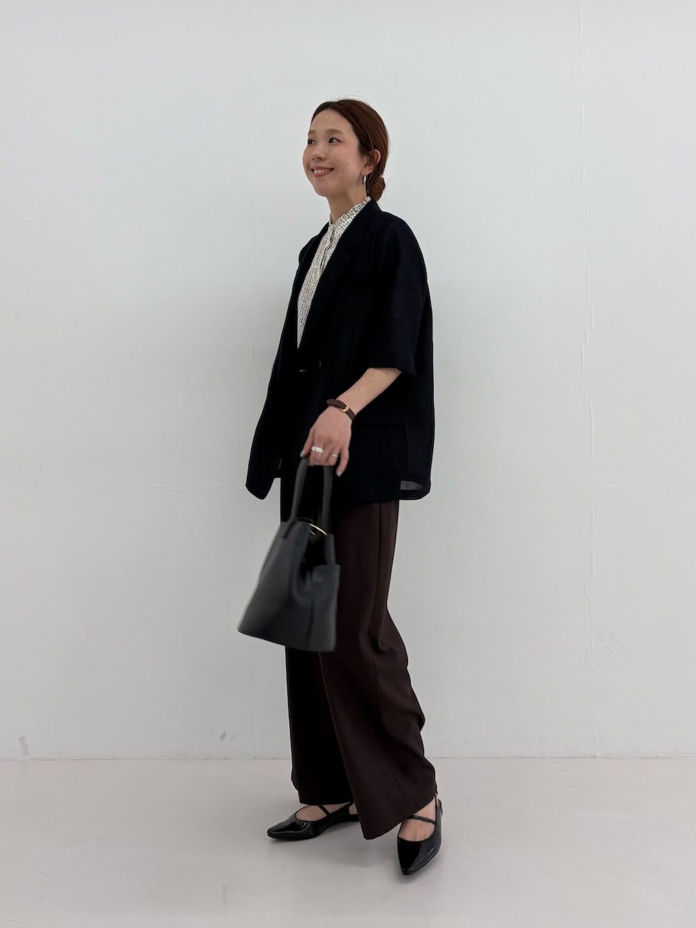 ブラック系のその他アウター、ホワイト系のシャツ/ブラウス、ブラウン系のその他パンツを着用したレディースの春コーディネートの2枚目の写真