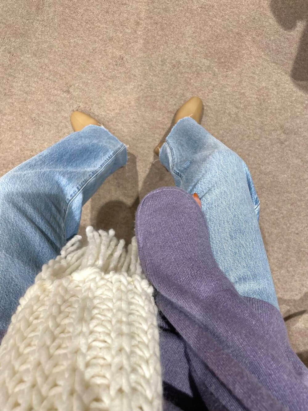 ブルー系のデニムパンツ、ベージュ系のブーツ、パープル系のニット/セーターを着用したレディースの冬コーディネートの5枚目の写真