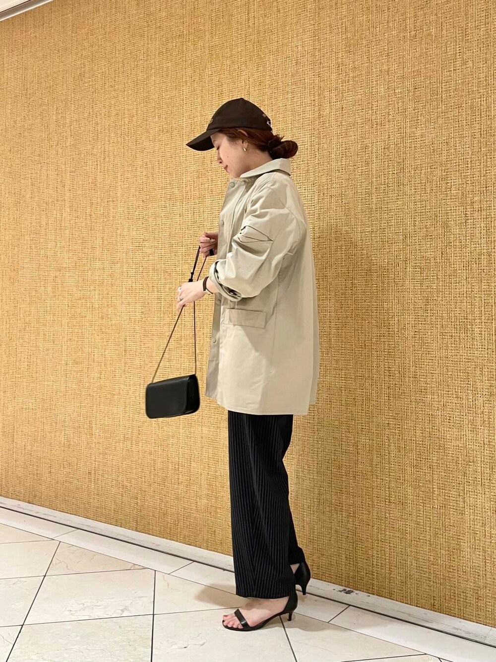 ブラック系のショルダーバッグ、ブルー系のその他パンツ、ブラウン系のその他アウターを着用したレディースの冬コーディネートの4枚目の写真