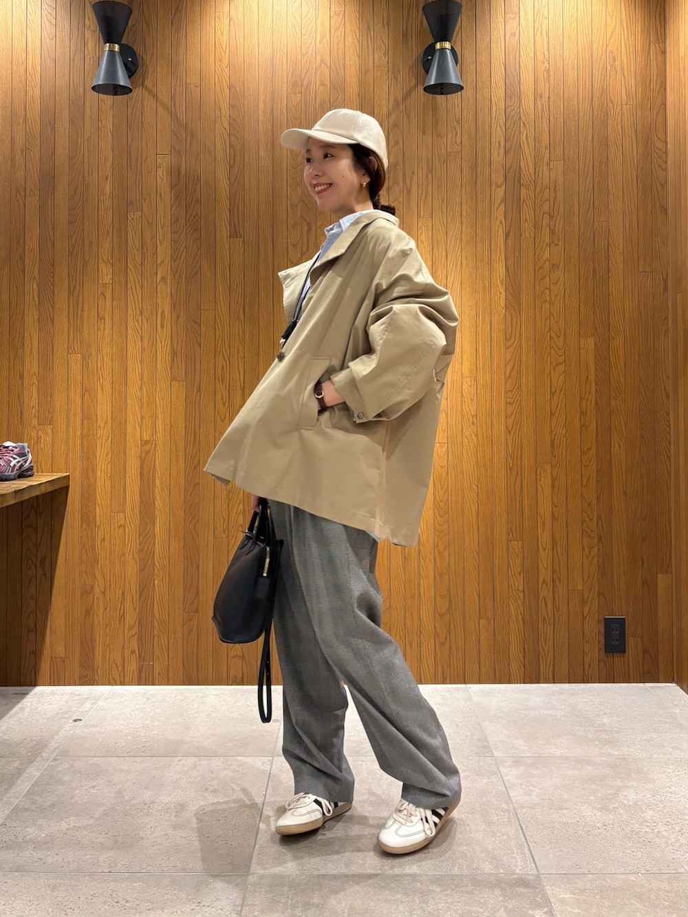 ホワイト系のスニーカー、ブルー系のシャツ/ブラウス、ベージュ系のトレンチコートを着用したレディースの春コーディネートの2枚目の写真