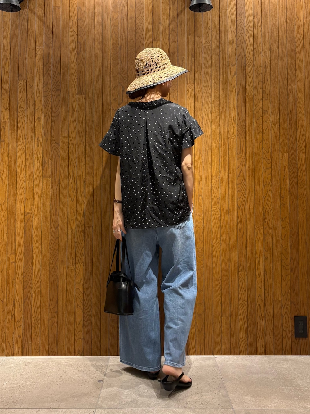ブラック系のシャツ/ブラウス、ブルー系のデニムパンツ、ブラック系のサンダルを着用したレディースの春コーディネートの3枚目の写真