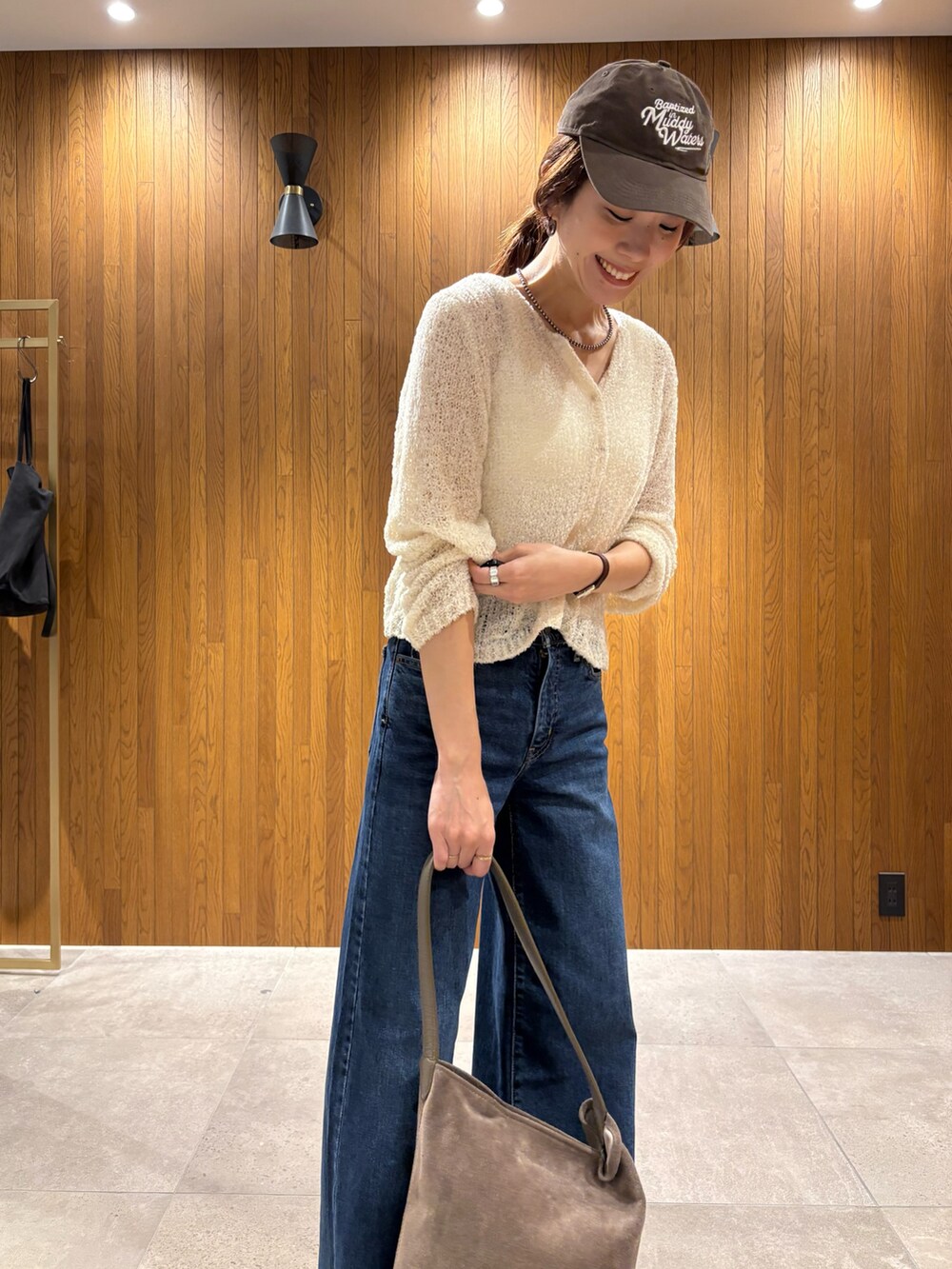 ブルー系のデニムパンツ、ブラウン系のトートバッグ、ベージュ系のブーツを着用したレディースの秋コーディネートの7枚目の写真