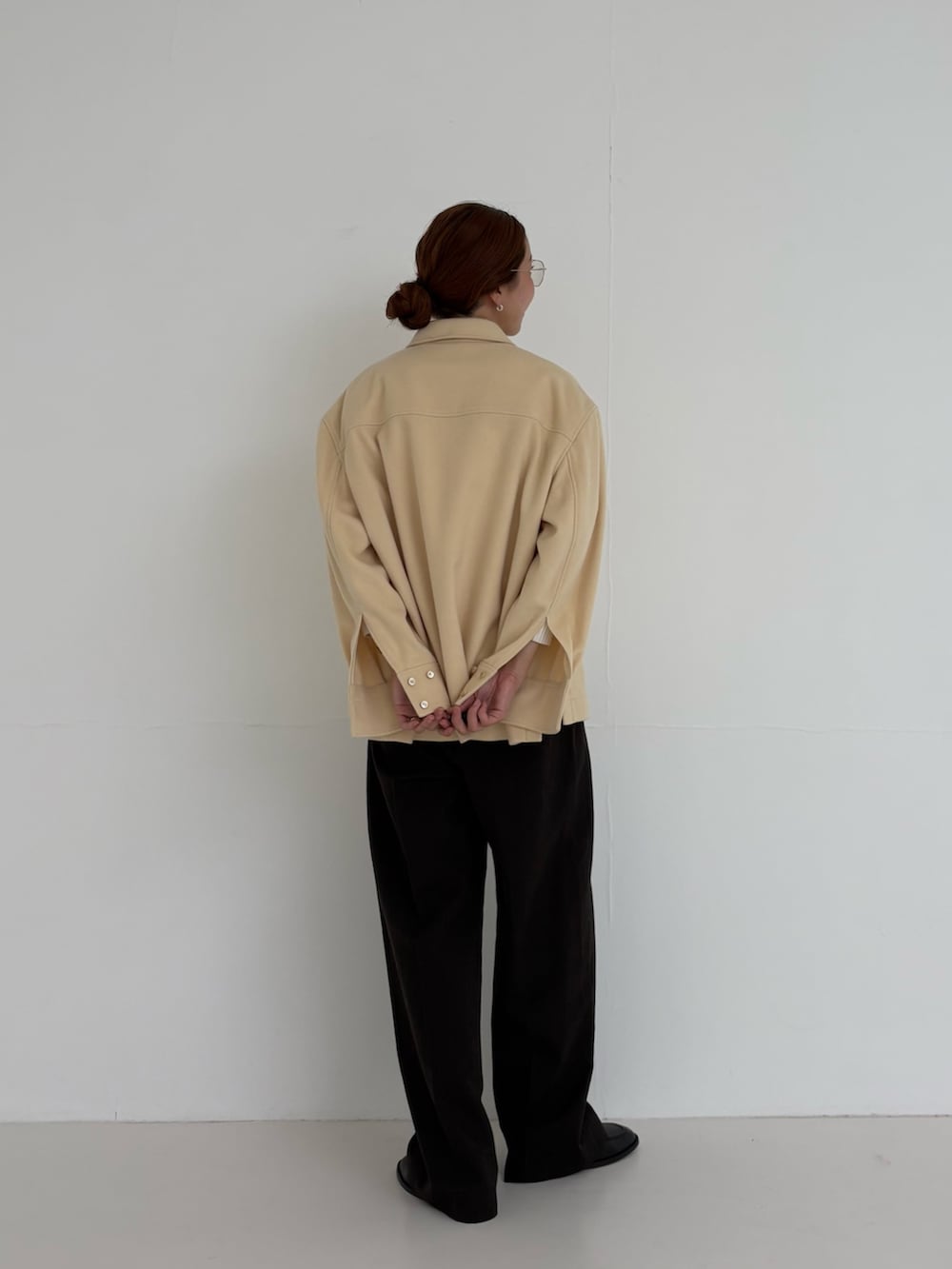 ホワイト系のニット/セーター、ブラウン系のその他パンツ、ゴールド系のメガネを着用したレディースの秋コーディネートの4枚目の写真