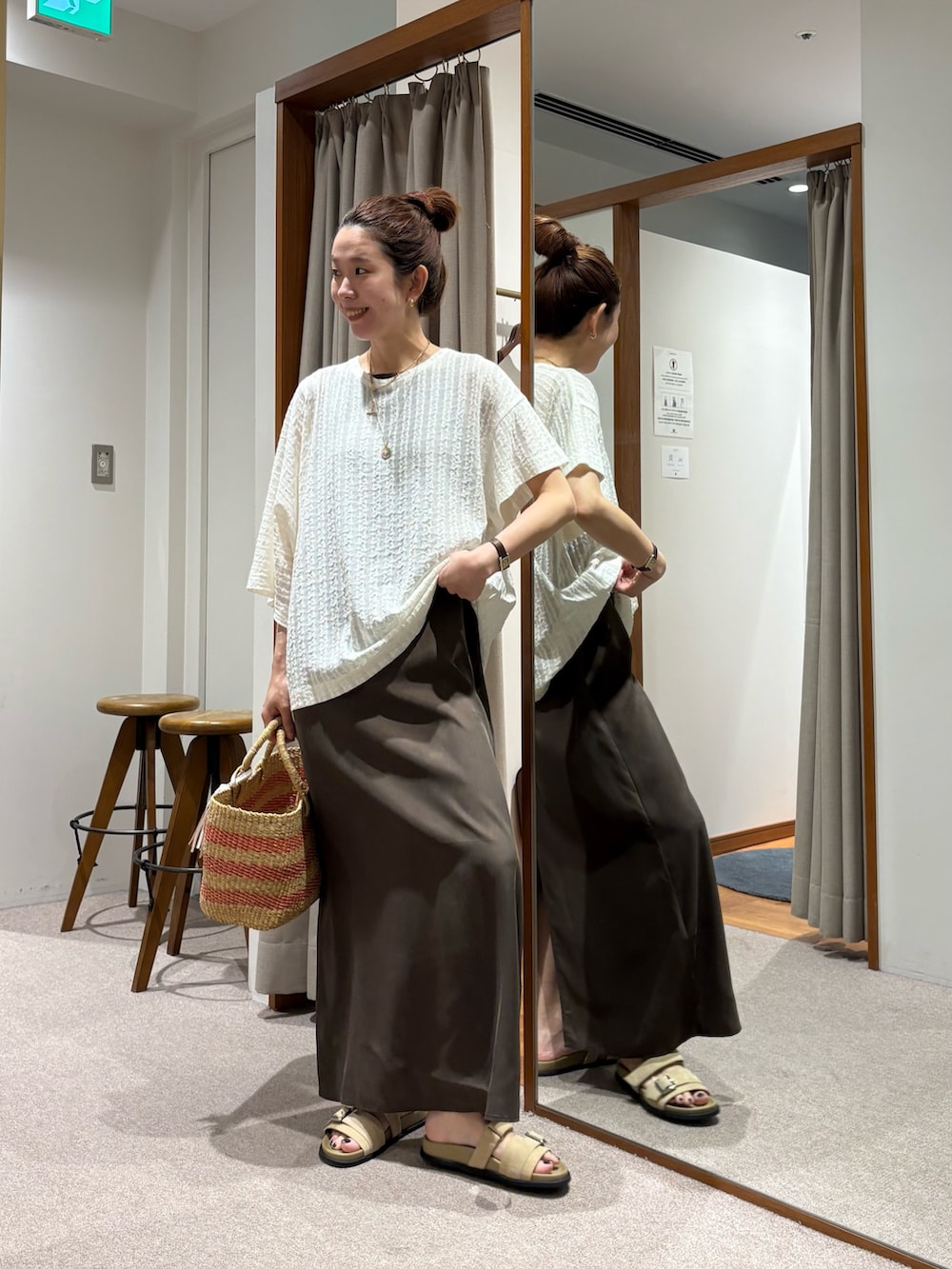 ブラウン系のワンピース、ホワイト系のTシャツ/カットソー、ベージュ系のかごバッグを着用したレディースの夏コーディネートの6枚目の写真