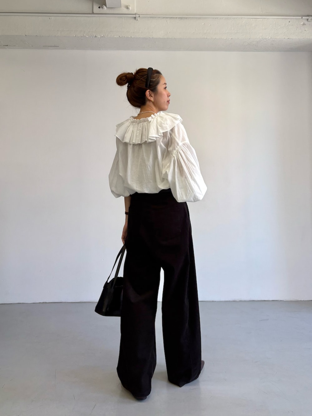 グレー系のその他パンツ、ホワイト系のシャツ/ブラウス、ブラック系のハンドバッグを着用したレディースの秋コーディネートの5枚目の写真