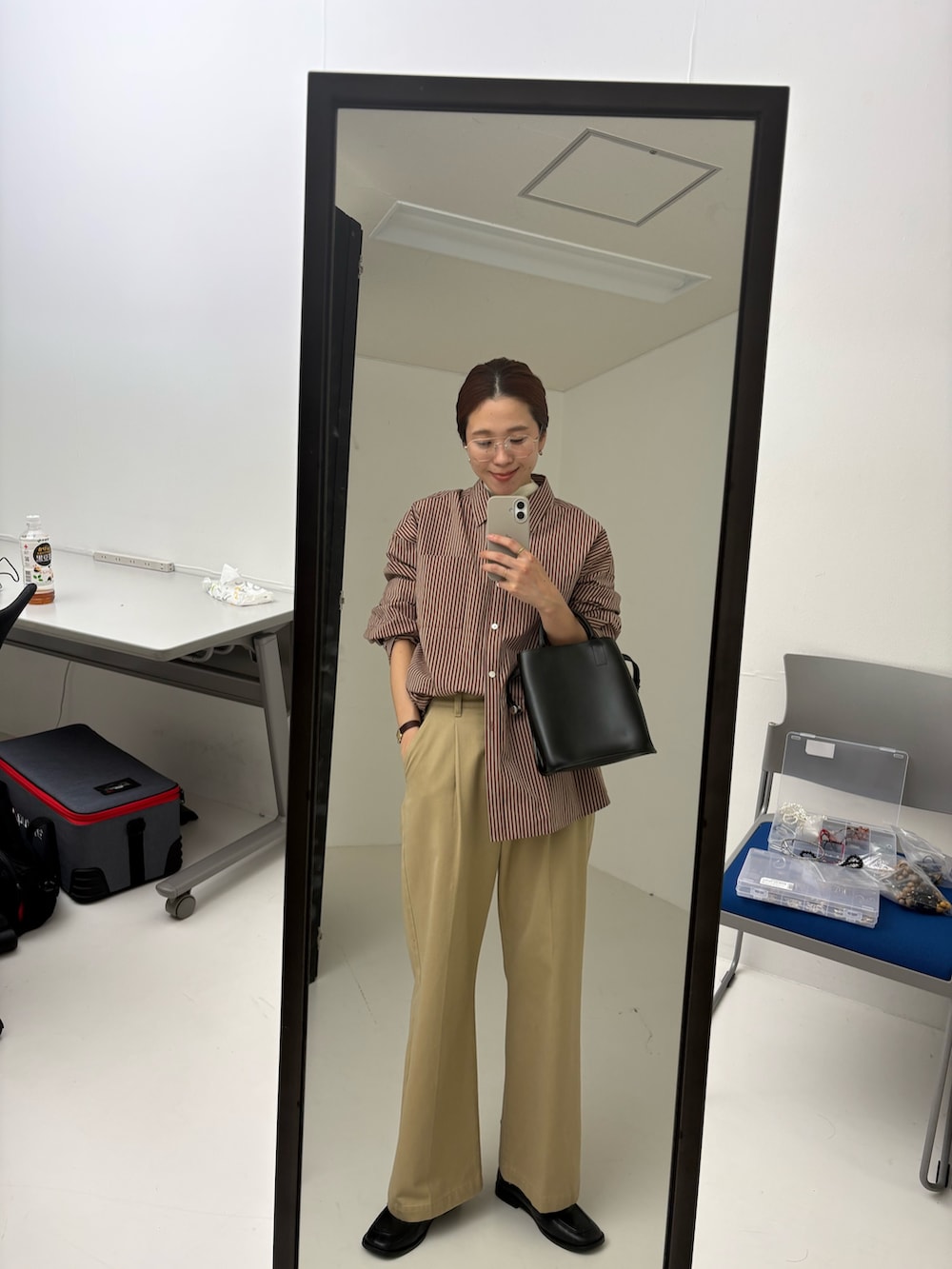 ブラウン系のその他アウター、レッド系のシャツ/ブラウス、ベージュ系のその他パンツを着用したレディースの秋コーディネートの6枚目の写真