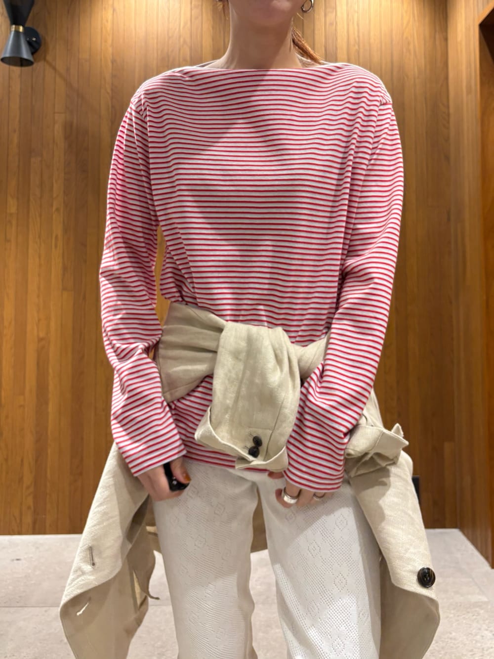 ベージュ系のその他アウター、レッド系のTシャツ/カットソー、ブラック系のハンドバッグを着用したレディースの春コーディネートの5枚目の写真