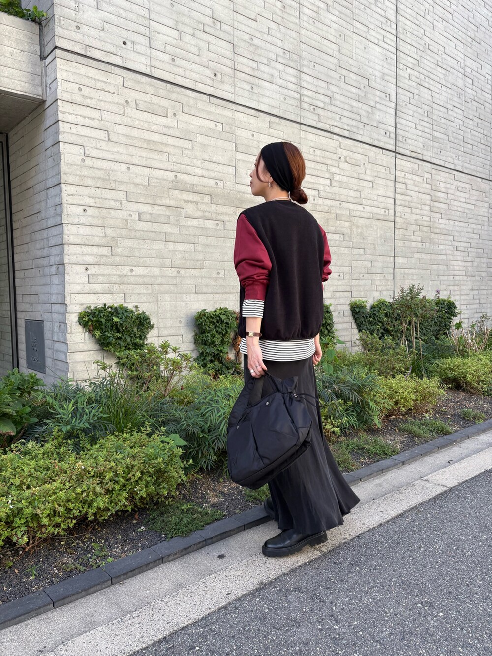 レッド系のスウェット、ブラック系のスカート、ブラック系のショルダーバッグを着用したレディースの秋コーディネートの3枚目の写真