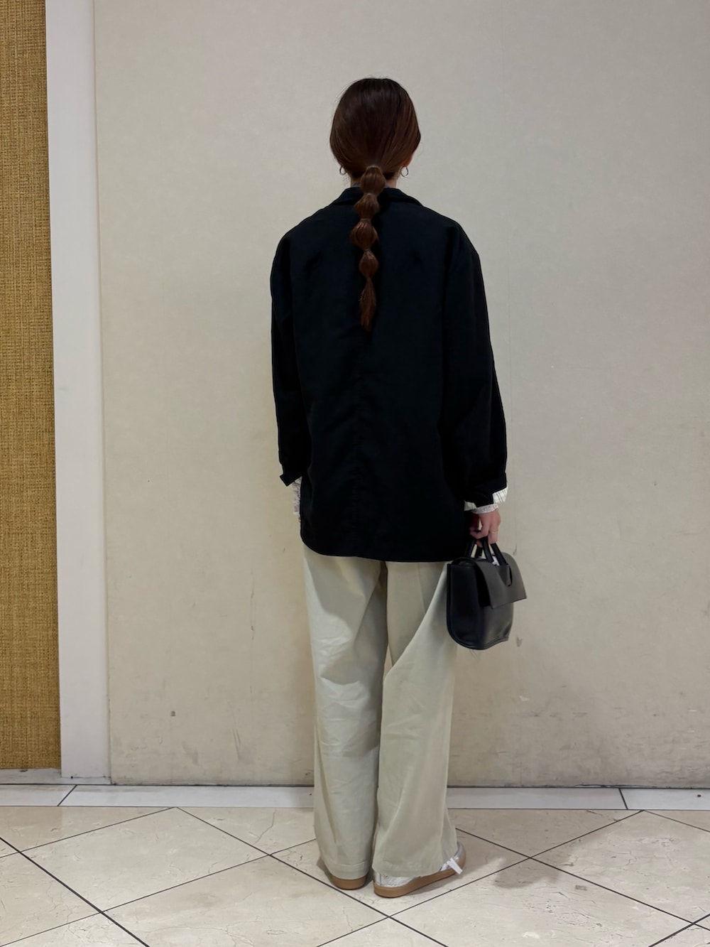 ブラック系のその他アウター、ベージュ系のその他パンツ、シルバー系のスニーカーを着用したレディースの春コーディネートの3枚目の写真