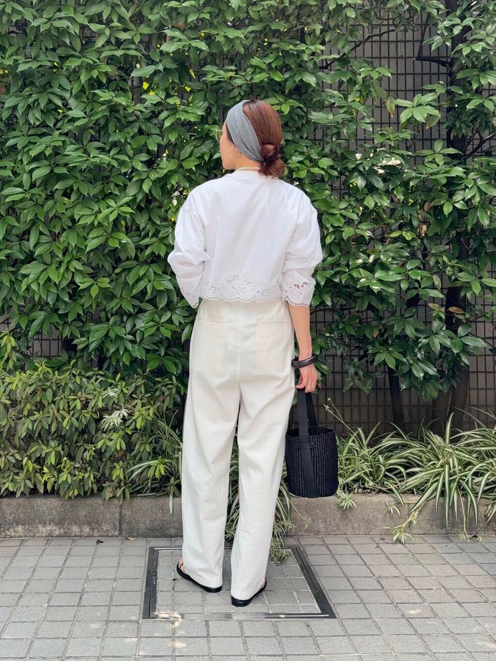 ブラック系のかごバッグ、ホワイト系のその他パンツ、ブラック系のサンダルを着用したレディースの夏コーディネートの4枚目の写真