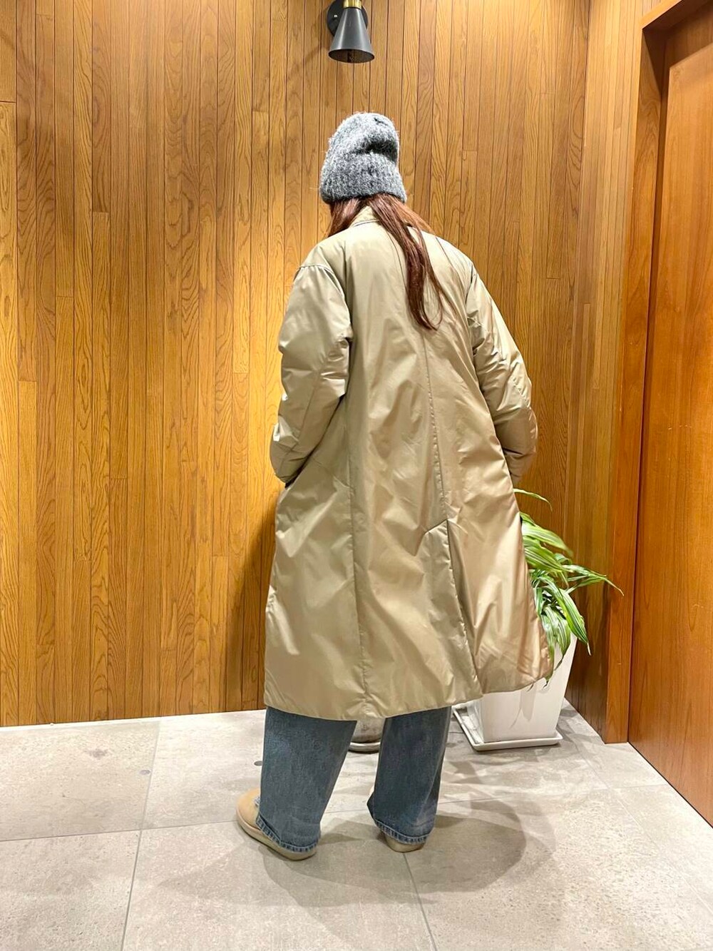 ブルー系のデニムパンツ、グレー系のカーディガン/ボレロ、ベージュ系のダウンジャケット/コートを着用したレディースの秋コーディネートの4枚目の写真