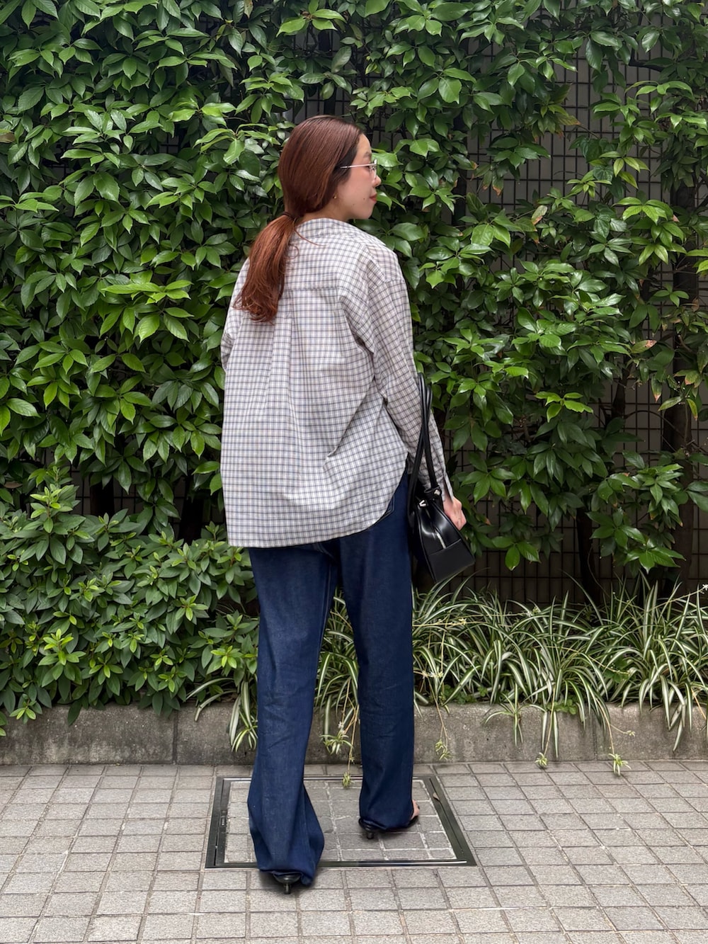 ブルー系のデニムパンツ、ブラック系のショルダーバッグ、ホワイト系のタンクトップを着用したレディースの夏コーディネートの9枚目の写真