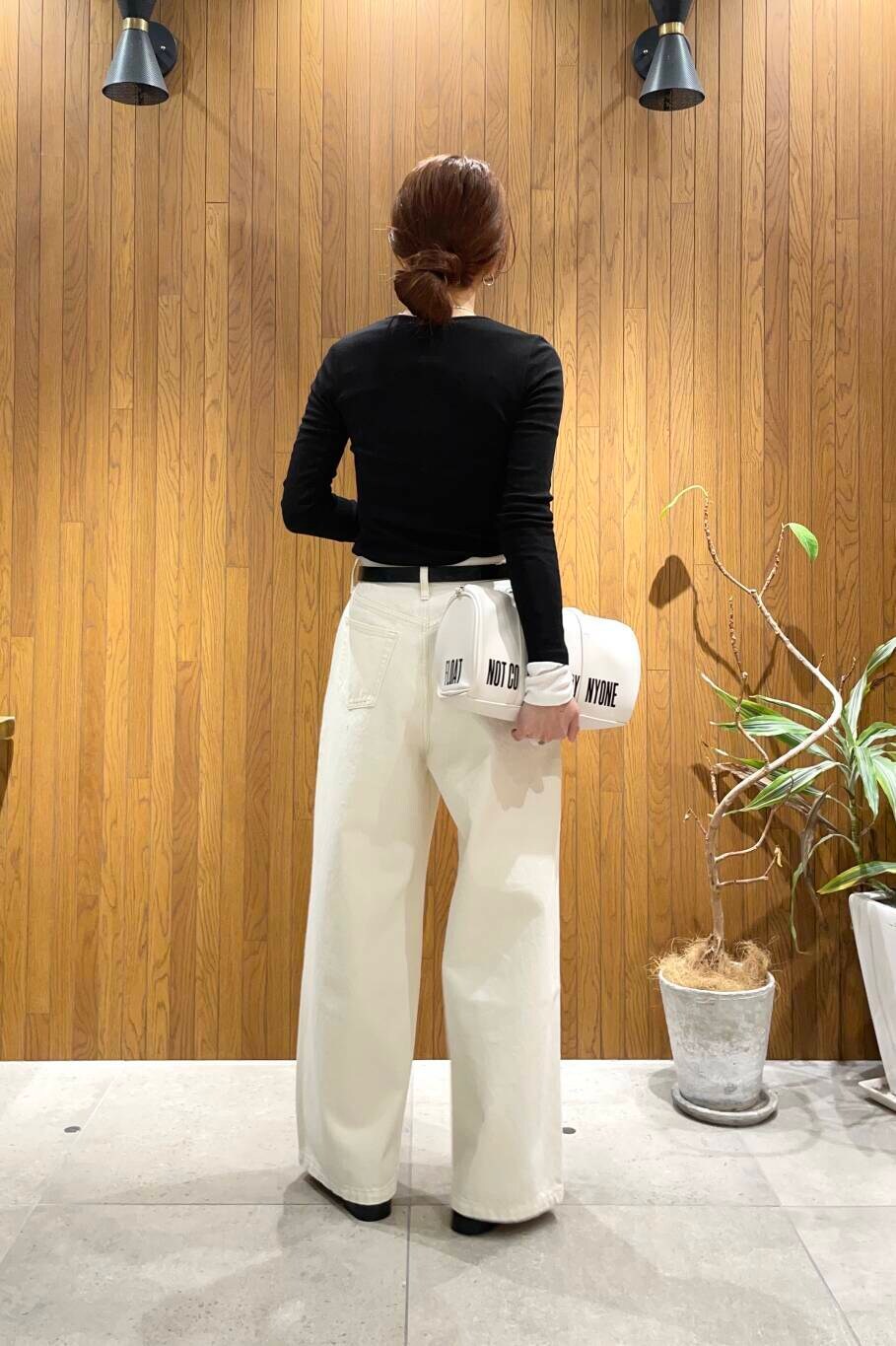 ブラック系のローファー、ホワイト系のボストンバッグ、ホワイト系のデニムパンツを着用したレディースの冬コーディネートの4枚目の写真