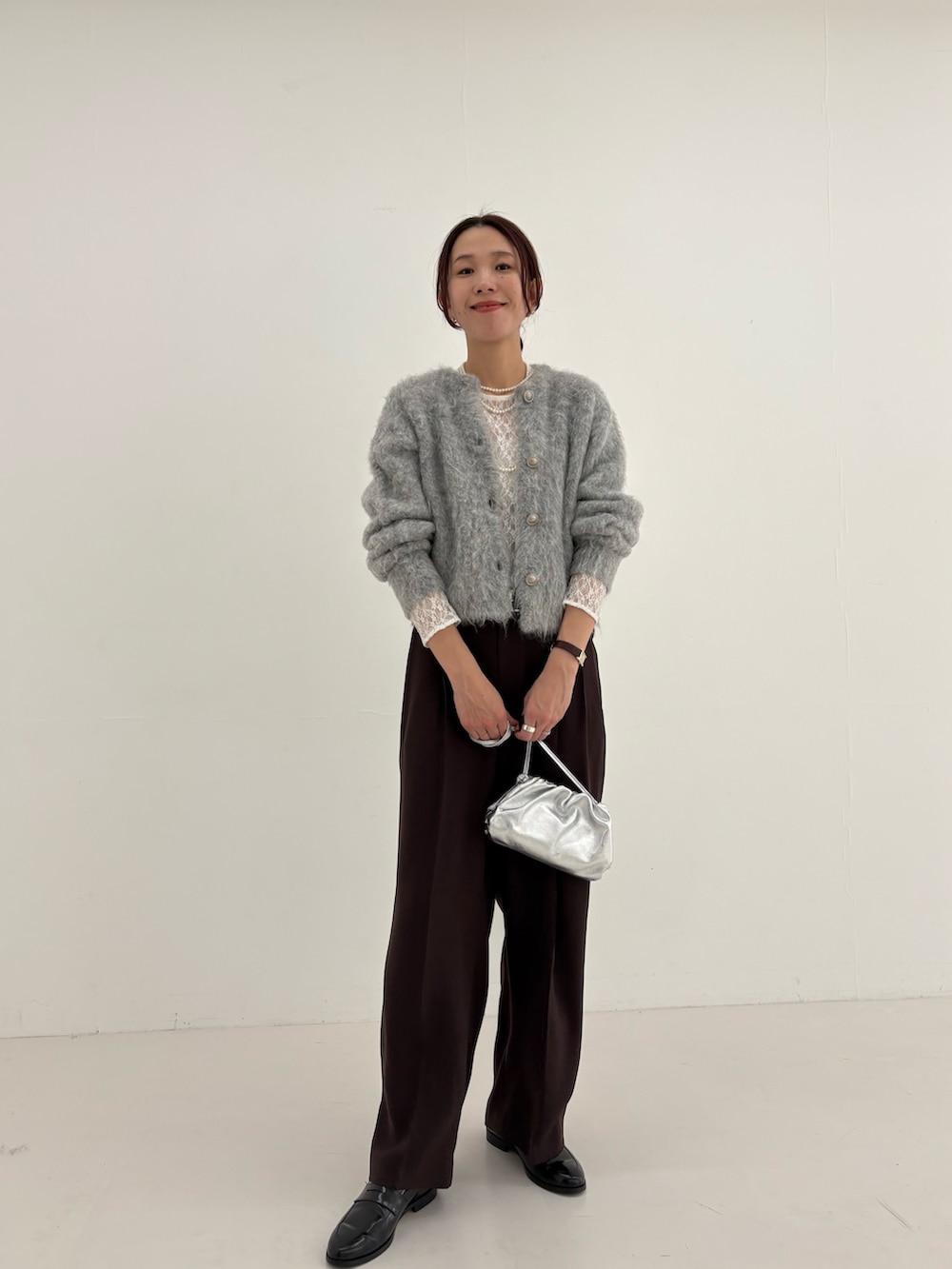 ブラウン系のその他パンツ、グリーン系のカーディガン/ボレロ、シルバー系のショルダーバッグを着用したレディースの秋コーディネートの8枚目の写真