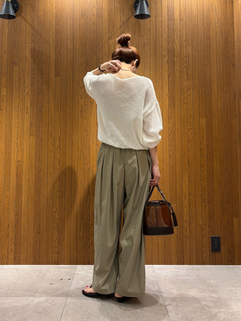 ホワイト系のニット/セーター、ベージュ系のその他パンツ、ブラウン系のかごバッグを着用したレディースの春コーディネートの3枚目の写真