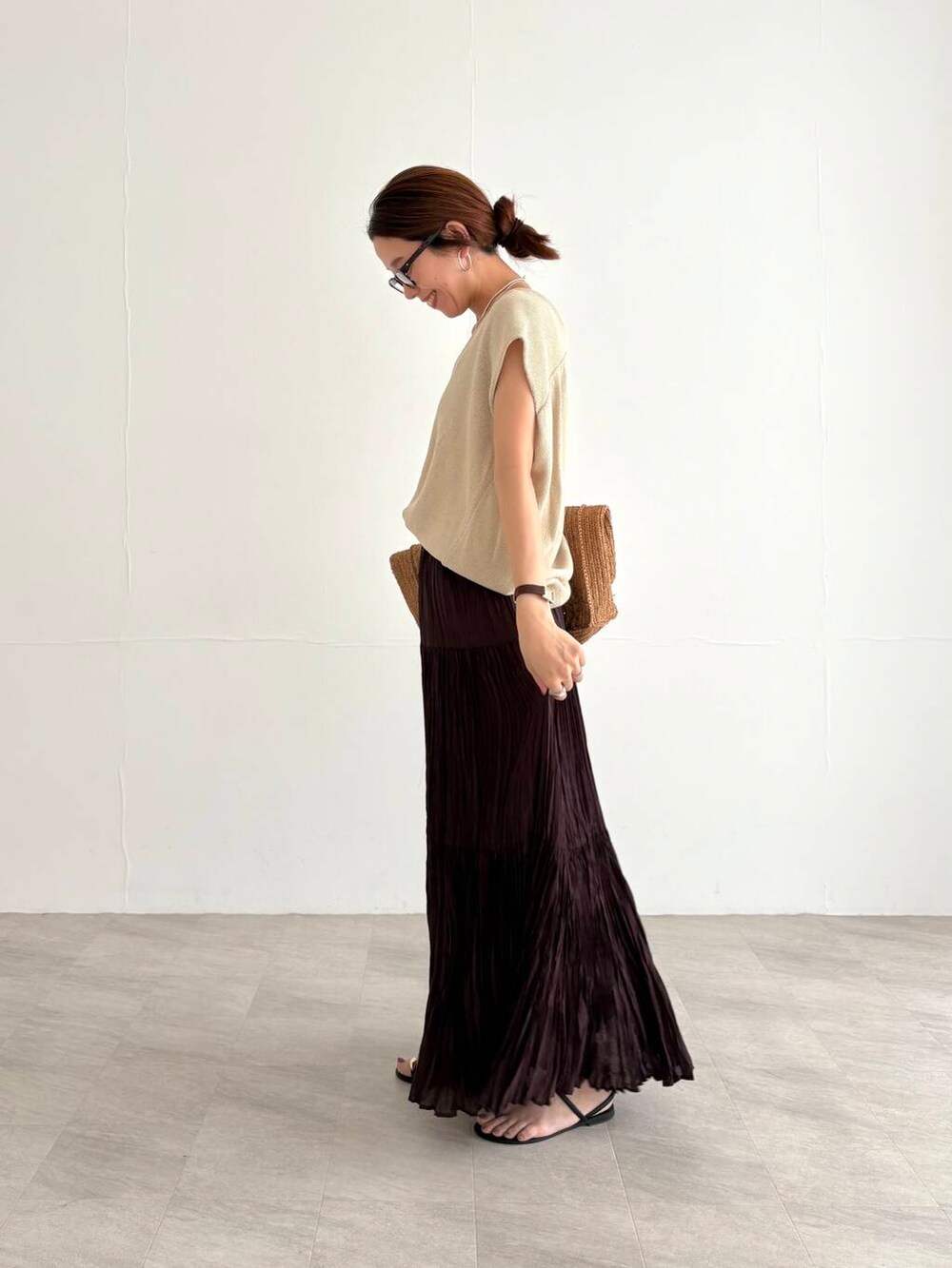 ホワイト系のキャミソール、ブラウン系のスカート、ベージュ系のベストを着用したレディースの夏コーディネートの2枚目の写真