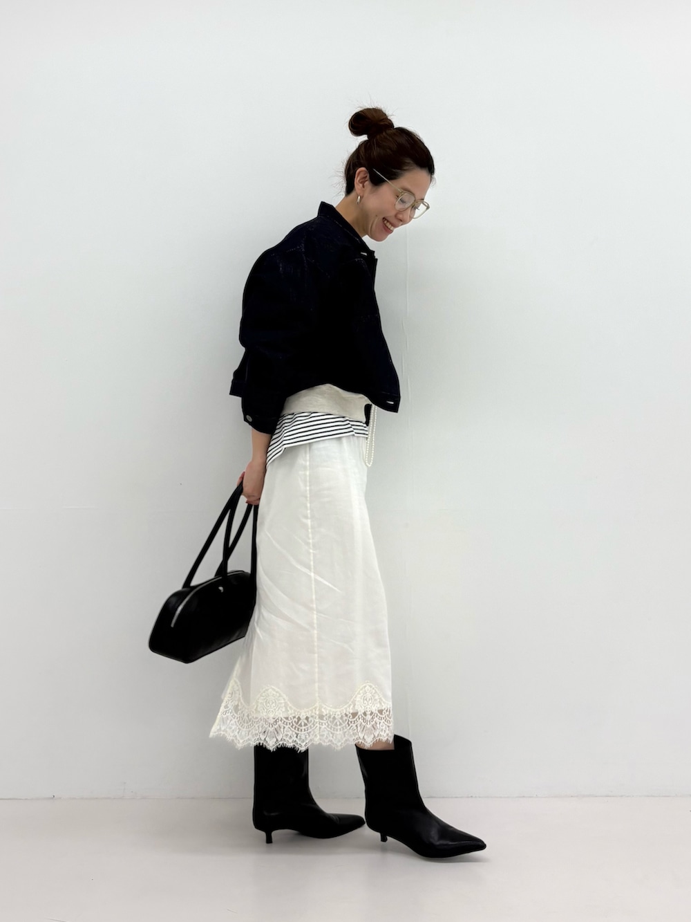 ブルー系のデニムジャケット、ベージュ系のスウェット、ブラック系のブーツを着用したレディースの冬コーディネートの3枚目の写真