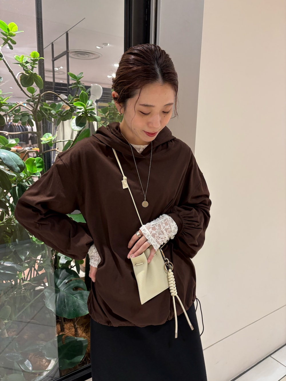 ブラウン系のパーカー、ホワイト系のスニーカー、ブラック系のスカートを着用したレディースの秋コーディネートの6枚目の写真